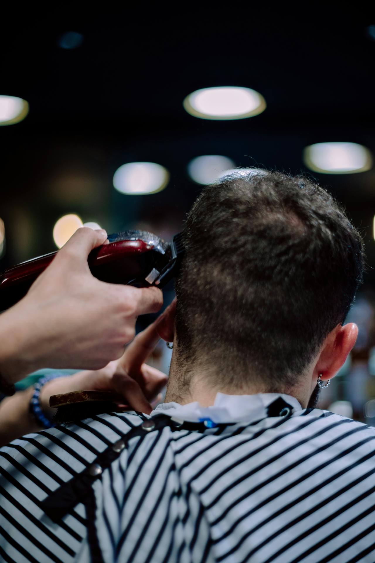 A young man getting a haircut at a stylish barber shop in Geneva, Switzerland.