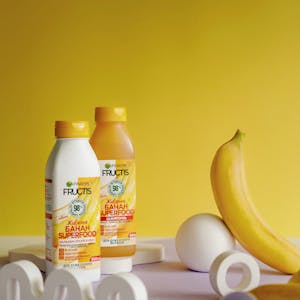 Vibrant product photography featuring Garnier Fructis Banana Hair Food.